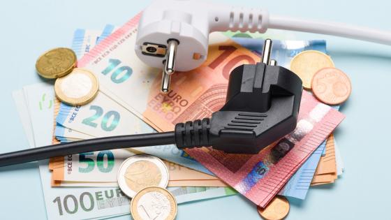 Two european electric power plugs on Euro banknotes and coins